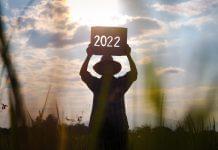 farmer in rice field holding new year 2022 sign