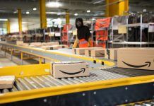 Amazon packages are sorted by warehouse workers on conveyors