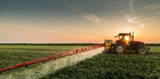 farmer spraying field with pesticides